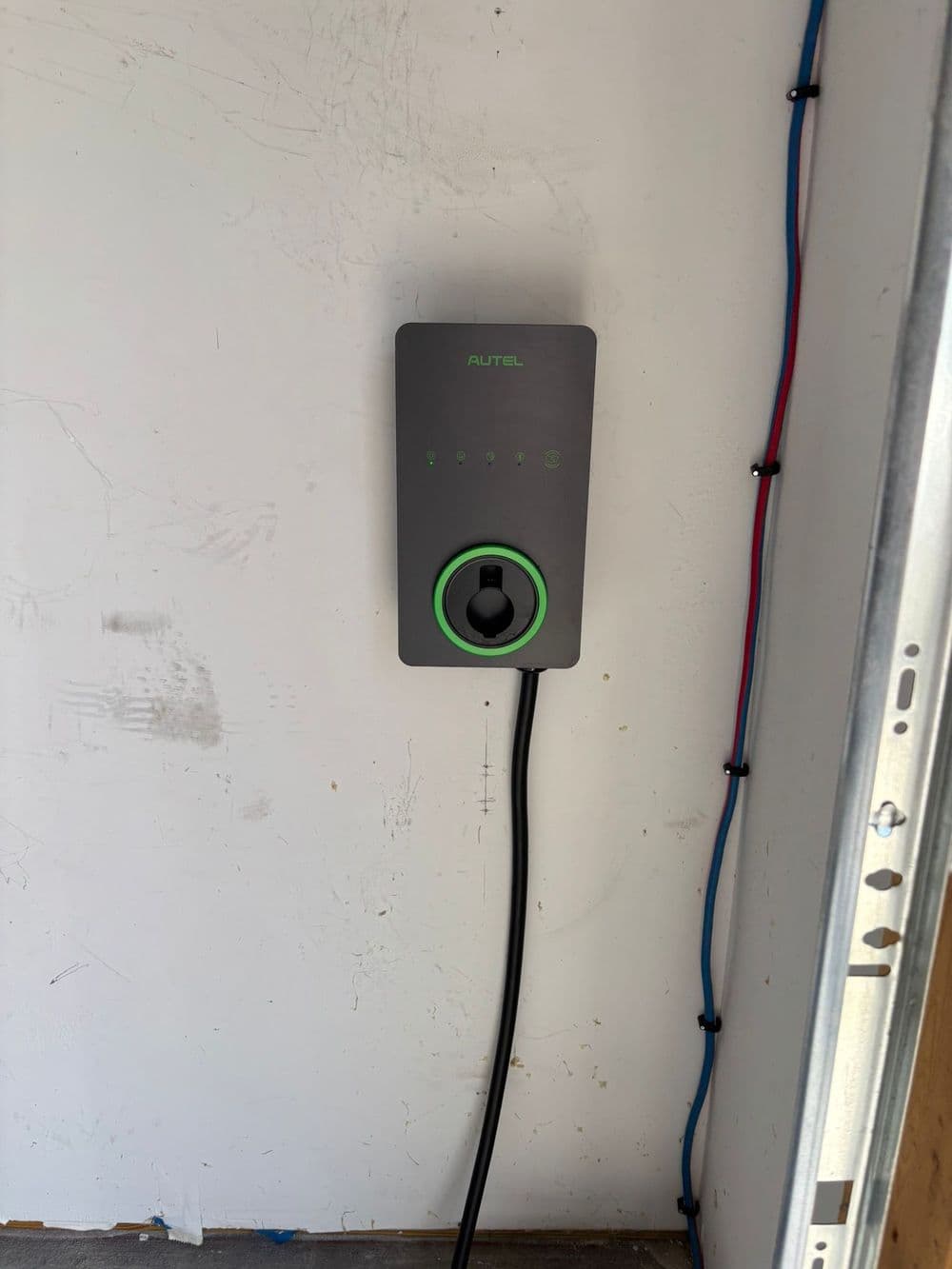 Autel electric vehicle charger mounted on wall with charging cable attached.
