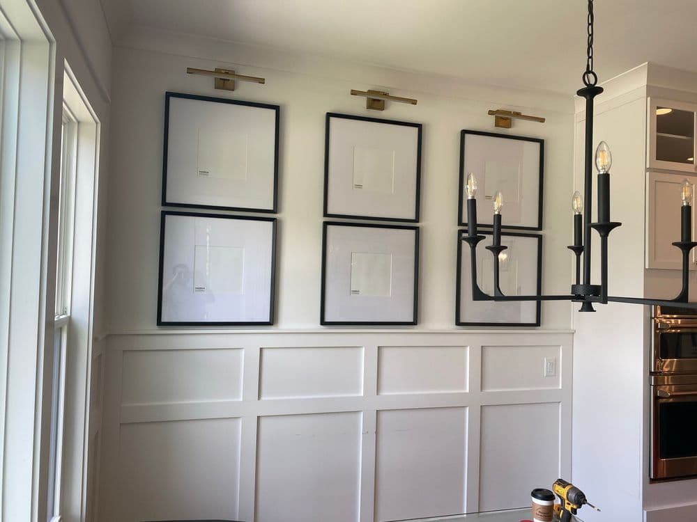 Contemporary dining area featuring framed art and stylish chandelier. Elegant design details.