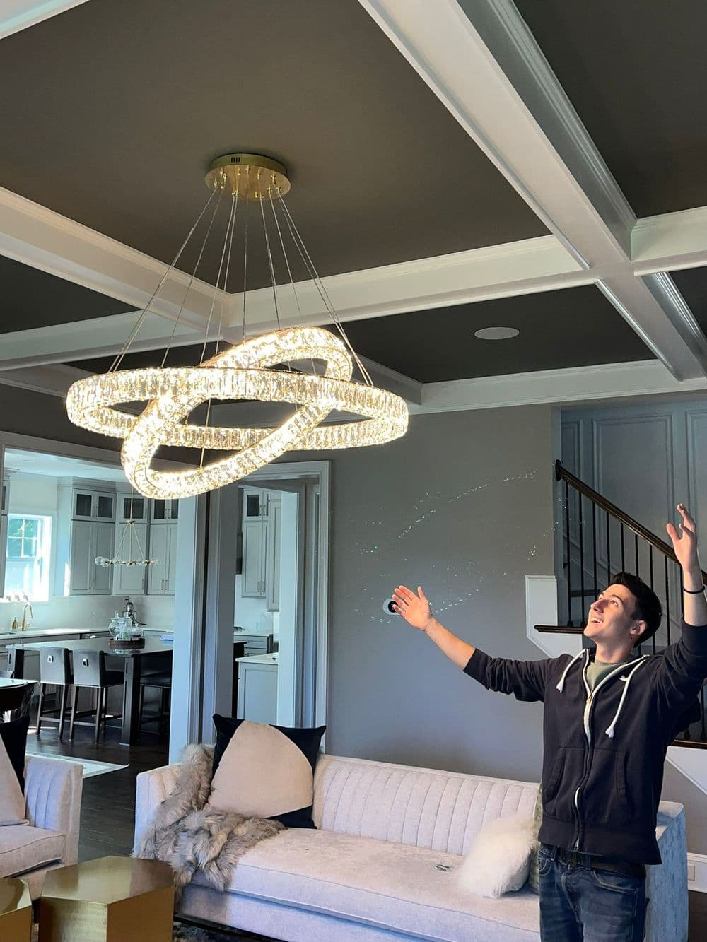 Modern chandelier in a stylish living room with a man admiring it. Elegant decor.