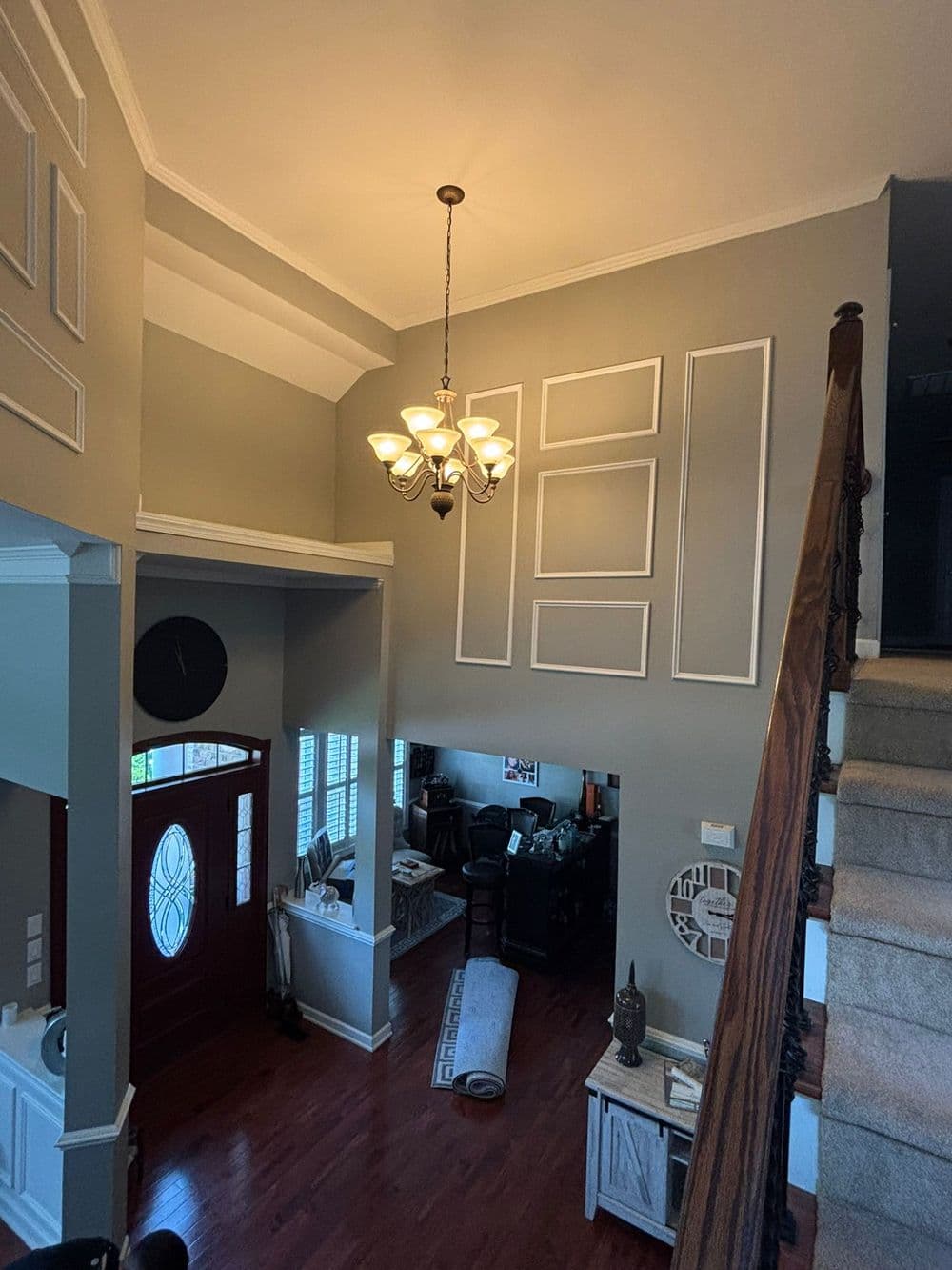 Modern entryway showcasing a chandelier, stairway, and stylish decor elements.