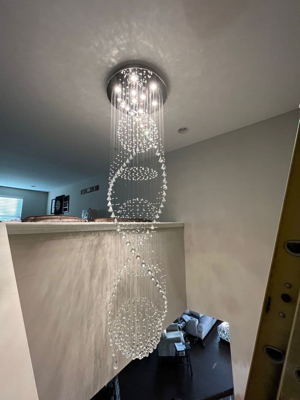 Modern spiral chandelier with crystal accents illuminating a contemporary interior space.