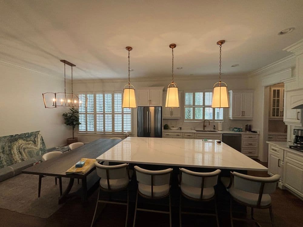 Modern kitchen with large island, white cabinetry, and pendant lighting over dining area.